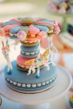 a blue carousel with pink, white and blue icing on it's top