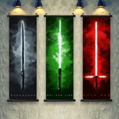 three star wars posters with lightsabers on them hanging from the wall in a room