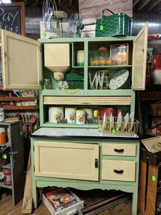 an old green cabinet with many items on it