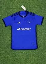 a blue soccer jersey with the word betfair on it is laying on green grass