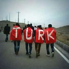 several people walking down the road with red jackets that say turk and white letters on them