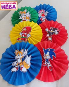 four different colored paper fans with sonic the hedgehog stickers on them, each featuring an individual's own character