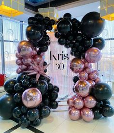 black and pink balloons are arranged in the shape of an arch for a 30th birthday party