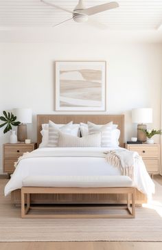 a bed with white sheets and pillows in a bedroom