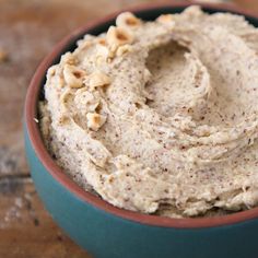 a bowl filled with hummus and nuts on top of a table