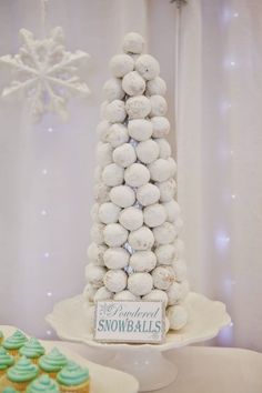 a christmas tree made out of snowballs sitting on top of a white cake plate