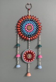 a colorful wall hanging with beads and tassels