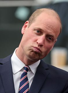 a man in a suit and tie making a face