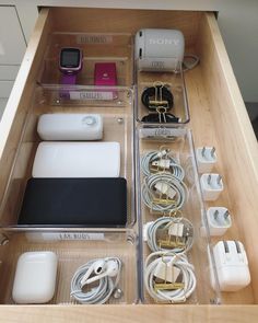 an open drawer containing various electronics and cords