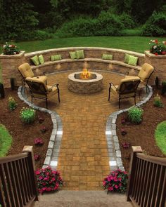 an outdoor fire pit surrounded by chairs and flowers