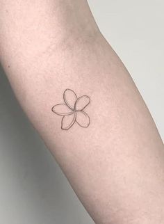 a small flower tattoo on the arm