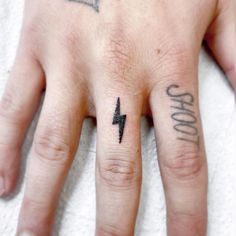 a person's hand with two small tattoos on it