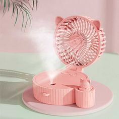 a pink fan sitting on top of a white plate