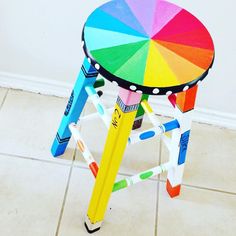 a multicolored stool sitting on top of a tiled floor