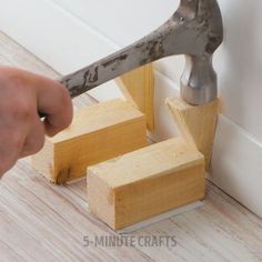 someone is using a hammer to cut wood blocks with a small block on the floor