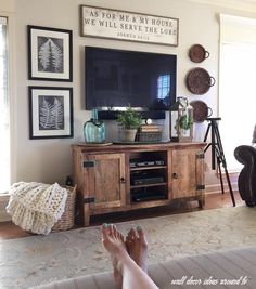 a person's feet resting on the floor in front of a flat screen tv