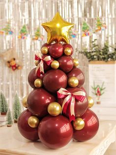 a christmas tree made out of red balls and gold ornaments with a star on top