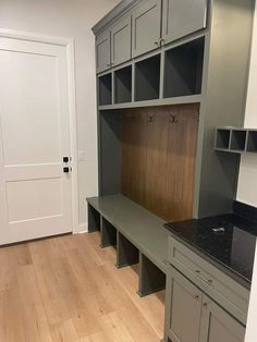 an empty room with gray cabinets and black counter tops