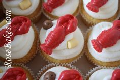 cupcakes with white frosting and red icing in the shape of a fish