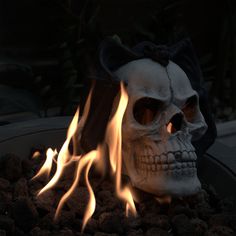 a skull sitting on top of a pile of rocks with flames coming out of it