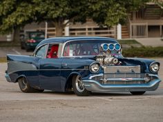 an old blue car is parked in a parking lot