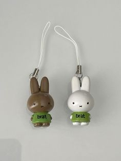 two plastic keychains that have animals on them, one is brown and the other is white