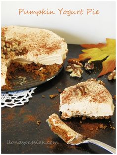 a pumpkin yogurt pie on a table with a slice missing from the cake