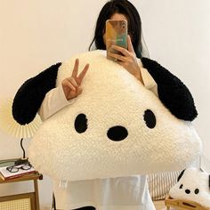 a woman taking a selfie with her cell phone in front of a stuffed animal