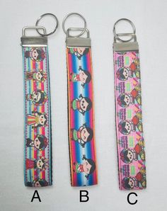 three key chains with cartoon characters on them