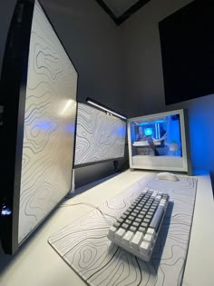 a computer keyboard sitting on top of a desk next to a monitor and mouse pad