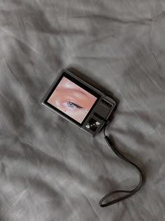 an electronic device with a camera attached to it's side laying on a bed