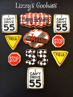 cookies decorated with different types of signs and numbers on a black background that says happy birthday