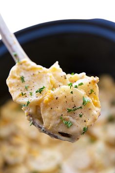 a spoon full of food with potatoes and parsley