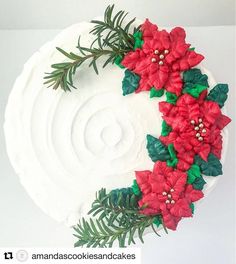 a cake decorated with red flowers and green leaves