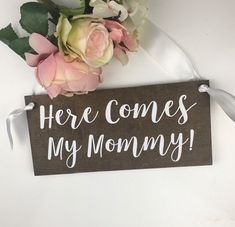 there is a sign that says here comes my mommy with flowers on top of it