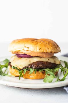 a hamburger on a plate with lettuce and cheese