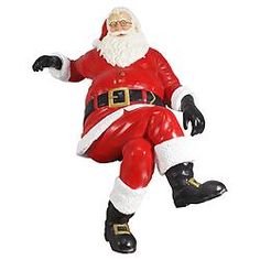 a santa clause figurine sitting on top of a white surface with his legs spread out