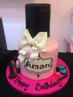 a pink birthday cake with a black top and white bow