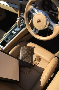 the interior of a luxury car with an electronic device and purse on the dash board