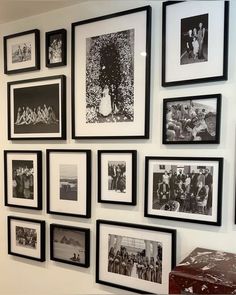 black and white photographs are hung on the wall above a suitcase in front of them