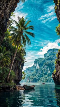 an island with palm trees and boats on the water in front of it, surrounded by mountains