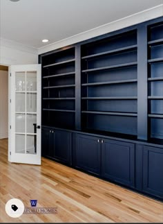 an empty room with blue bookcases and wood flooring in front of it