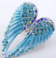 an angel wing brooch with blue crystals