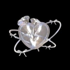 a heart shaped object with two small hearts on it's sides and an attached wire