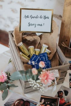 a wooden box filled with lots of different items on top of a white table cloth