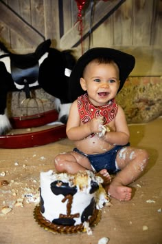 a baby sitting in front of a cake