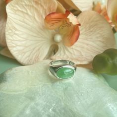 This timeless jade ring features an 18K white gold setting that encases a stunning, highly translucent jadeite cabochon in a sleek bezel arrangement. The centerpiece is a Type A jade cabochon displaying a vibrant apple green.  The remarkable translucency of the jadeite material beautifully complements the subtle pastel hue, enhancing the ring's classic design with an aura of refinement, attributed to the exceptional quality of the jade focal point. Crafted with slightly thicker bezels, the 18K g Modern Oval Green Jewelry, Modern Cabochon Emerald Ring For Formal Occasions, Classic Round Chrysoprase Rings, Modern Formal Emerald Cabochon Ring, Modern Cabochon Emerald Ring, Modern Emerald Oval Cabochon Ring, Modern Round Cabochon Emerald Ring, Modern Jade Jewelry For Anniversary, Modern Green Oval Rings