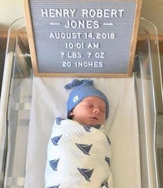 a baby in a crib with a name sign on the wall above it that says henry robert jones