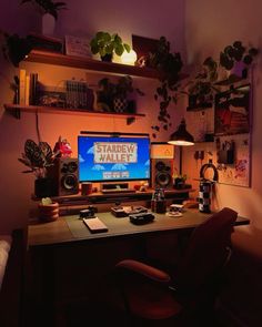 a computer desk with a monitor and speakers on top of it in a dark room