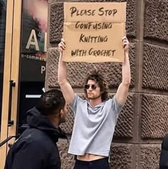 a man holding up a sign in front of a building